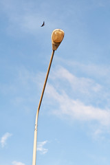  electric street light pole over blue sky with clouds.