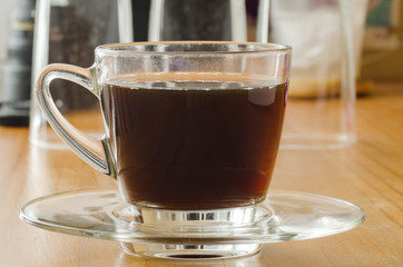 The cup of hot coffee on wooden background in the morning