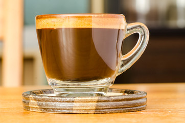 The cup of hot coffee on wooden background in the morning
