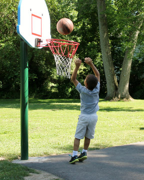 Child Playing Basketball Outdoors