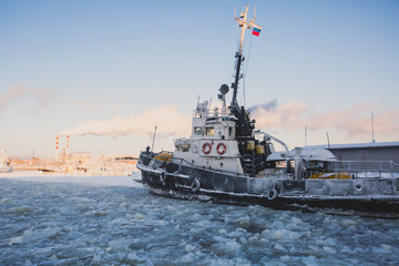 The Icebreaker ship trapped in ice tries to break and leave the arctic bay between the glaciers
