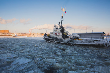The Icebreaker ship trapped in ice tries to break and leave the arctic bay between the glaciers
