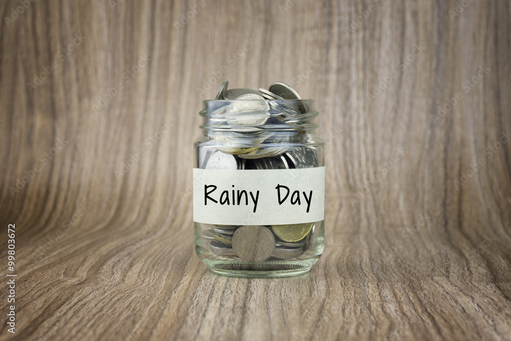 Wall mural glass jars with coins labeled rainy day. financial conceptual