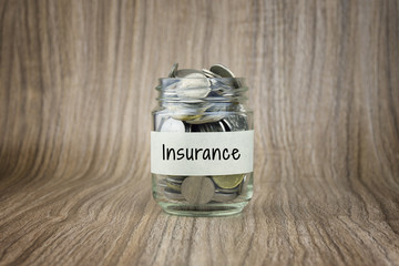 Glass jars with coins labeled Insurance. Financial Conceptual