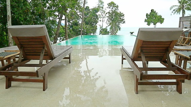 Sun beds near the swimming pool in rainy weather