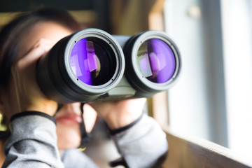 Woman looking though binoculars at indoor