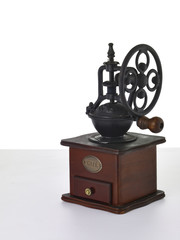 Old wooden coffee grinder with handle on white