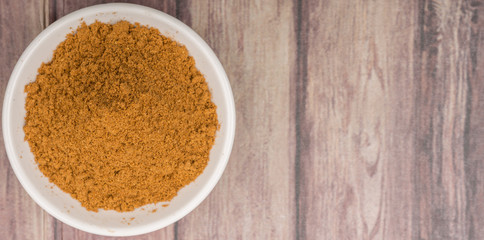 Garam masala or mix spices blend in white bowl over wooden background