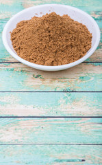 Garam masala or mix spices blend in white bowl over wooden background