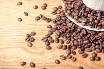 Fresh coffee beans on a wooden background for the preparation of