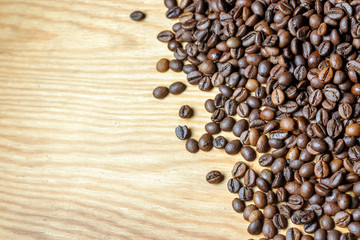 Fresh coffee beans on a wooden background for the preparation of