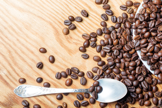 Fresh coffee beans on a wooden background for the preparation of