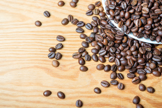 Fresh coffee beans on a wooden background for the preparation of