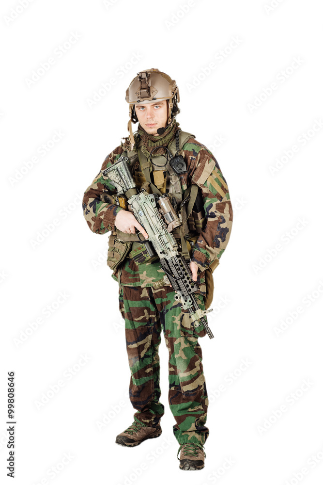 Wall mural young ranger standing with a machine gun at white background