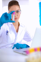 Woman researcher is surrounded by medical vials and flasks, isolated on white background