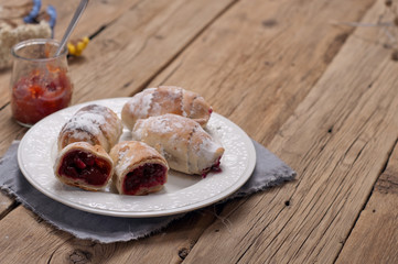 Homemade croissant with a cherry on a white plate