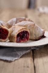 Homemade croissant with a cherry on a white plate