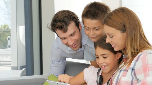 Parents with children websurfing on digital tablet