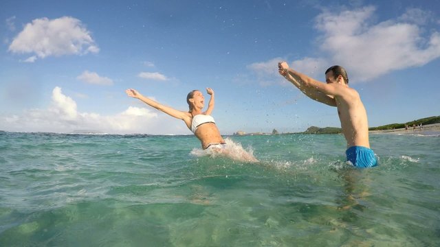 Man pushing his girlfriend into sea water