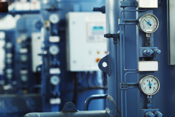 Closeup image of barometers at a brewery industrial plant.