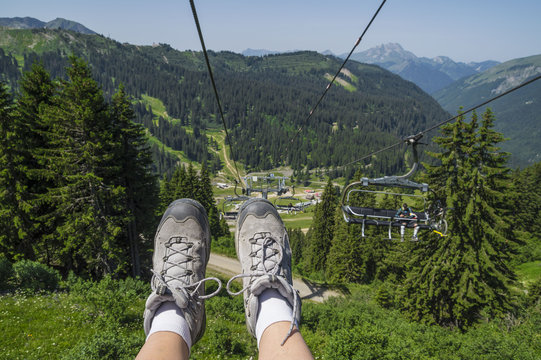 Freedom ,up In The Air ,with Hiking Shoes -  Close-up, In A Chair Lift Above The Mountains.