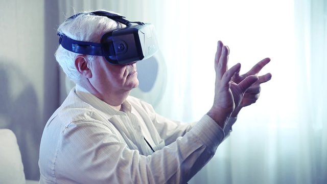 the silver-haired old man  getting experience using VR-headset glasses of virtual reality 
