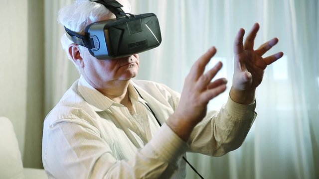 old man  getting experience using VR-headset glasses of virtual reality  at home