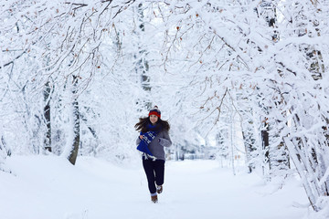 Girl running in winter park snow vacation