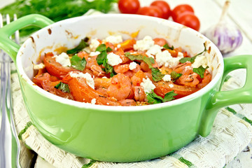 Shrimp and tomatoes with feta in pan on napkin