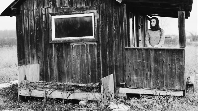 The poor girl on the threshold of the old post-war building. RAW video record.
