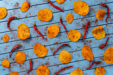 Crispy potato chips on blue wooden table