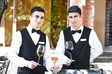 Waiters holding glasses of wine