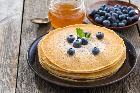 crepes with fresh blueberries and honey, close-up