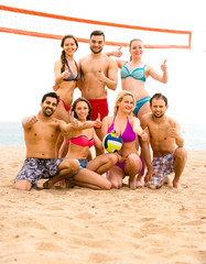 Volleyball players posing near sea