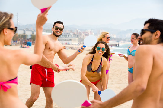 Friends playing matkot on a beach