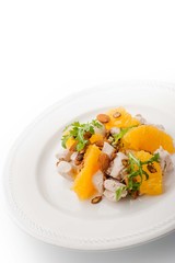 Salad with chicken and orange on the white plate vertical