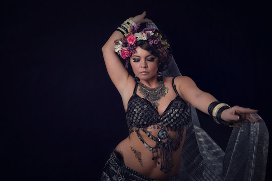 Frau beim orientalischen Bauchtanz mit Kost&uuml;m und Blumen im Haar