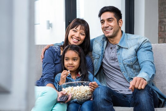 Smiling Family Eating Popcorn While Watching Tv