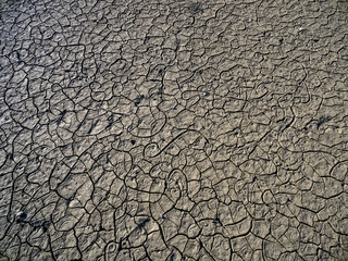 Dry lake bed with natural texture of cracked clay in perspective