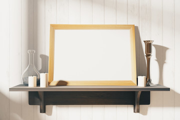 Blank white picture frame with candlesticks on brown wooden shel