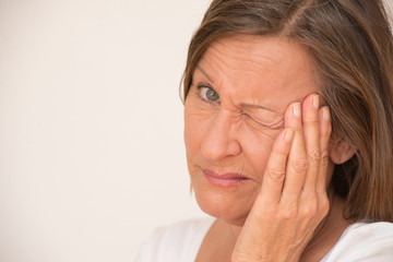 Fototapeta premium Worried angry upset woman one eye closed