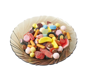 Glass plate full of candies isolated