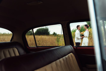 unusual view of stylish bride and happy groom through red retro