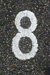 White number eight painted on asphalt