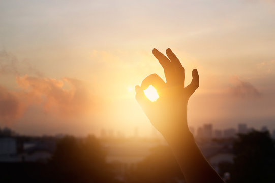 hand in the sunset, one sign of meditation in buddhism, soft  focus