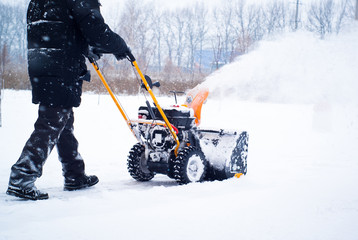 A man cleans snow - Powered by Adobe