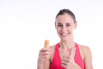 cheerful young caucasian woman eating diet cereal bar