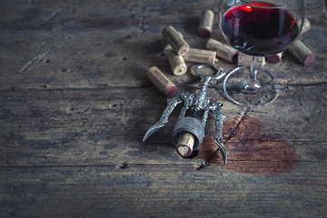 Rotwein im Rotweinglas auf einem Holztisch mit Korkenzieher