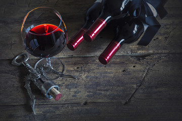 Rotwein im Rotweinglas auf einem Holztisch mit Korkenzieher