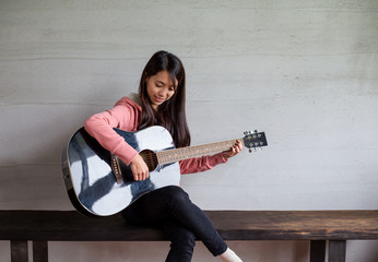 Asian Woman play with guitar at home